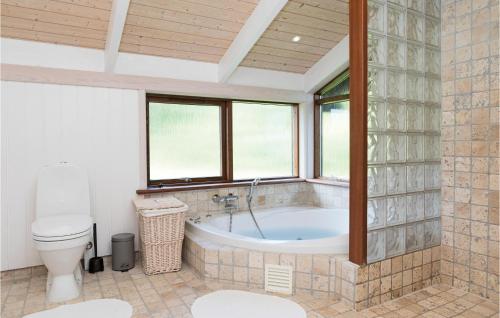y baño con bañera y aseo. en Beautiful Home In Hjrring With House Sea View, en Lønstrup