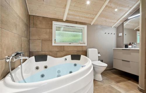 een badkamer met een wit bad en een toilet bij Awesome Home In Nordborg With Kitchen in Nordborg