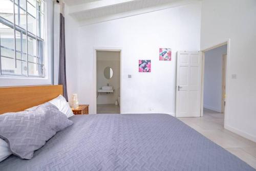 a bedroom with a bed and a large window at Reduit Orchard - Beautiful Home near Reduit Beach in Gros Islet