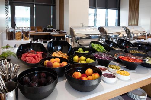 un buffet con cuencos de frutas y hortalizas en una mesa en Batumi View Luxury en Batumi