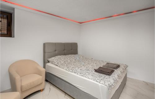 1 cama y 1 silla en una habitación en Stunning Apartment In Rab With Kitchen en Rab