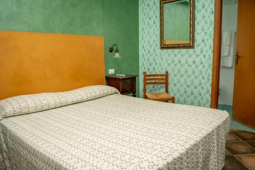 a bedroom with a bed and a chair and a mirror at Casale Villa Rainò in Gangi
