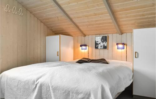 a bedroom with a large white bed with two lights at Stunning Home In Hvide Sande With Kitchen in Havrvig