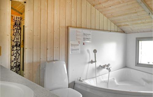 een badkamer met een bad, een toilet en een wastafel bij Stunning Home In Hvide Sande With Kitchen in Havrvig