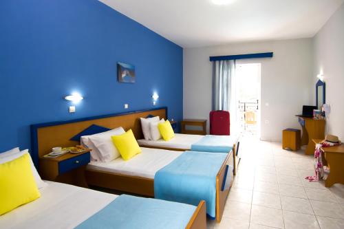 Habitación de hotel con 2 camas y pared azul en Hera Zakynthos Hotel, en Laganas