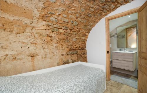 a bedroom with a stone wall and a bed at Awesome Home In Feliceto With House A Mountain View in Feliceto