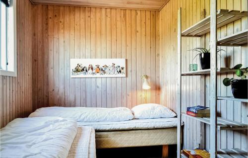 a bedroom with a bed in a wooden wall at Pet Friendly Home In Hvide Sande With Kitchen in Havrvig
