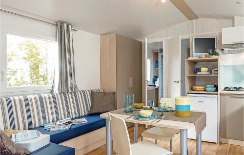 een woonkamer met een tafel en een blauwe bank bij Pet Friendly Home In Hvide Sande With Wifi in Hvide Sande