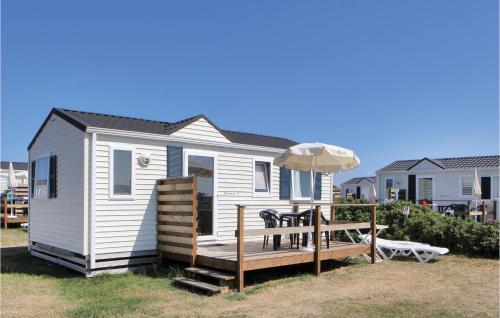 a tiny house with a bench and an umbrella at Pet Friendly Home In Hvide Sande With Wifi in Hvide Sande