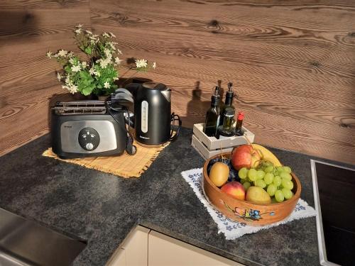 a kitchen counter with a basket of fruit and a toaster at Ferienwohnungen am Lärchenweg in Sesto