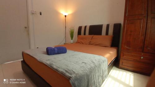 a bedroom with a bed with a blue pillow on it at D'ZAHRA HOME - with 30ft private pool in Melaka