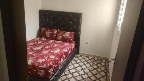 una camera con un letto con una coperta rossa di Les jardins d'Ifrane a Ifrane