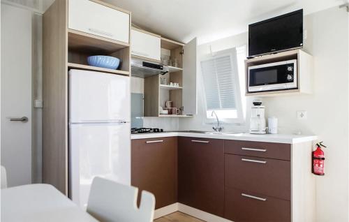 una pequeña cocina con nevera y microondas en Pet Friendly Home In Hvide Sande With House A Panoramic View, en Hvide Sande