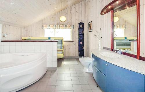 een badkamer met een bad, een wastafel en een toilet bij 4 Bedroom Amazing Home In Hvide Sande in Bjerregård