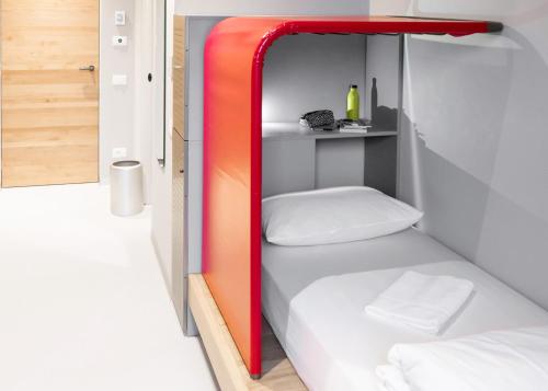 都靈的住宿－Combo Torino，红色和白色的房间里一张床位