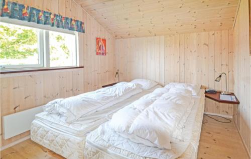 een bed in een kamer met een houten muur bij 4 Bedroom Amazing Home In Hvide Sande in Bjerregård