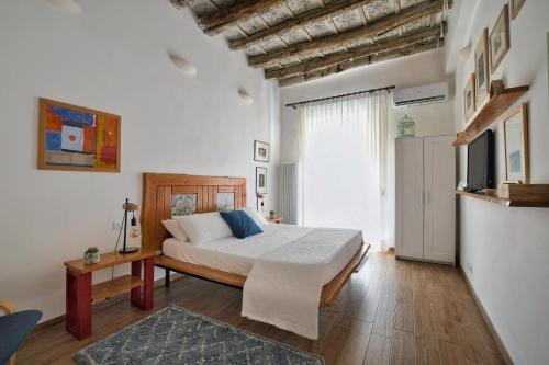 een slaapkamer met een bed en een televisie. bij iFlat Palazzo Ragusi in Palermo