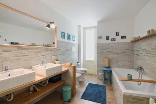 iFlat Palazzo Ragusi في باليرمو: حمام به مغسلتين وحوض استحمام ومرحاض