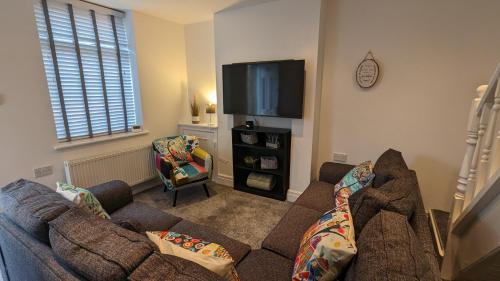 ein Wohnzimmer mit einem Sofa und einem Flachbild-TV in der Unterkunft 3 Bed City Home - South Facing Patio - 4-5 Beds in Lancaster