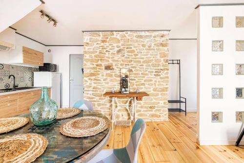 - une cuisine avec une table et un mur en pierre dans l'établissement Il était une fois à ConcarnOLoc, à Concarneau