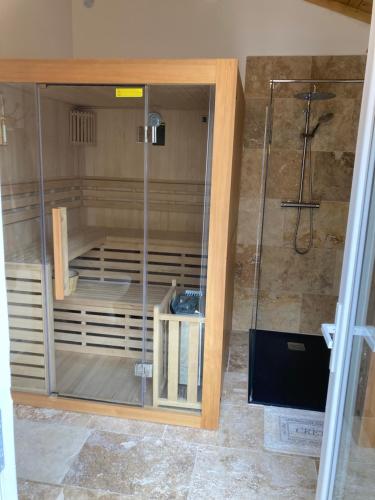 a shower with a glass door in a bathroom at Chez Janick & Hervé in Lemps