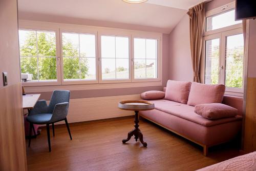 sala de estar con sofá, mesa y ventanas en Gasthof zur Bündte en Jenins