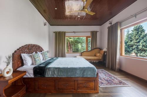 a bedroom with a bed and a window at StayVista at Pinewood Villa with Pool Table in Srinagar