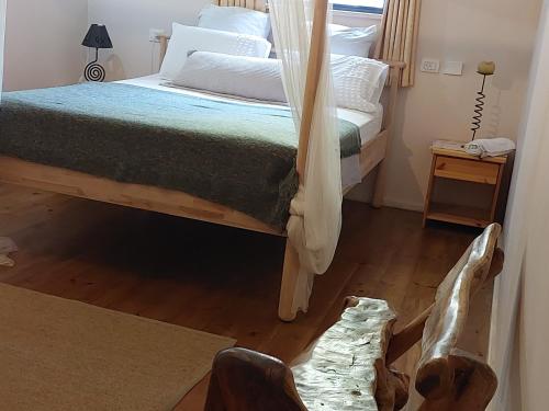 1 dormitorio con 1 cama y suelo de madera en Neve Nof, en Rosh Pina