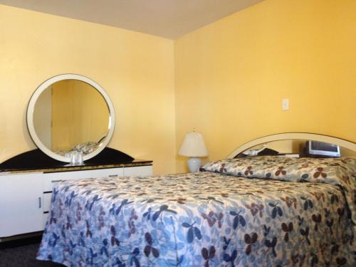 a bedroom with a bed and a round mirror at Motel Saint-Jacques in Montréal