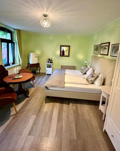 a bedroom with a large bed and a table at HEINRICHs winery bed & breakfast in Langenlonsheim