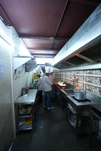 two chefs standing in a kitchen preparing food at Hotel Square One by D'Polo Dharamshala in Dharamshala