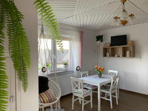 une salle à manger avec une table et des chaises blanches dans l'établissement Agroturystyka Pod Dzwonnicą, à Zubrzyca Górna