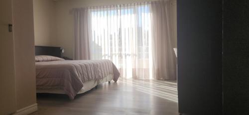 a bedroom with a bed and a large window at DAKAR HOTEL in Mendoza