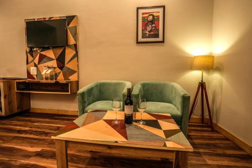 a room with a table and two chairs and a television at Hotel Square One by D'Polo Dharamshala in Dharamshala