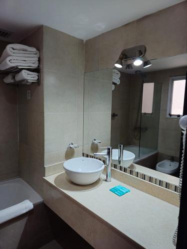 a bathroom with a sink and a large mirror at DAKAR HOTEL in Mendoza