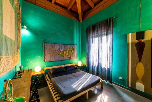 a bedroom with green walls and a bed and a desk at Speciale Tarshito's Home - Atrium and Terrace in Bari