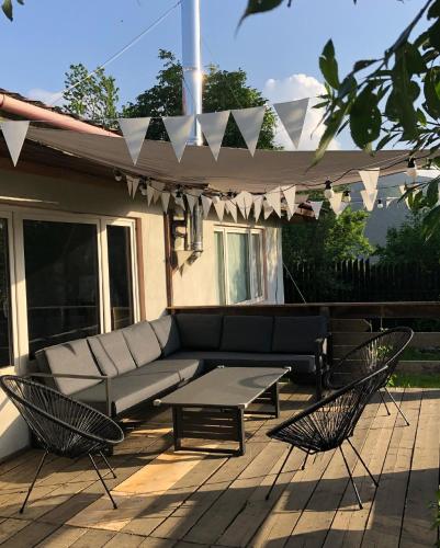 a patio with a couch and two chairs and a table at The Hygge House in Plopi