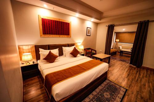 a hotel room with a bed and a living room at Hotel Square One by D'Polo Dharamshala in Dharamshala