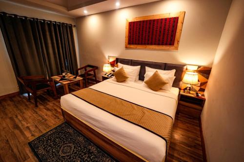 a hotel room with a bed with two tables and two lamps at Hotel Square One by D'Polo Dharamshala in Dharamshala