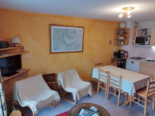 une cuisine avec une table et des chaises dans une pièce dans l'établissement Paradiski proche vanoise express plan peisey, à Peisey-Nancroix