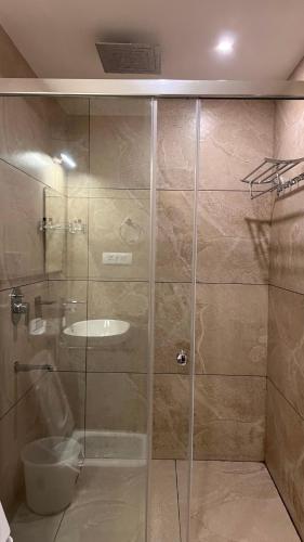 a bathroom with a shower with a toilet and a sink at The Wild Trails Clarks Exotica , Munnar in Munnar
