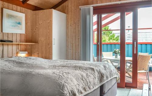 BjerregårdにあるStunning Home In Hvide Sande With Saunaのベッドルーム1室(大型ベッド1台付)、パティオが備わります。