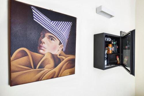 a painting of a woman with a hat on a wall at Boutique Hotel Piazza Carità in Naples