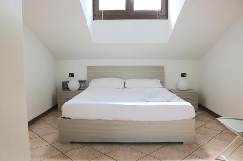 a bedroom with a white bed and a window at Lovely Apartment near Canal - Via Foscolo in Corsico