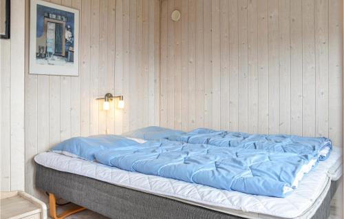 BjerregårdにあるNice Home In Hvide Sande With Saunaの大型ベッド1台(ブルーシーツ付)