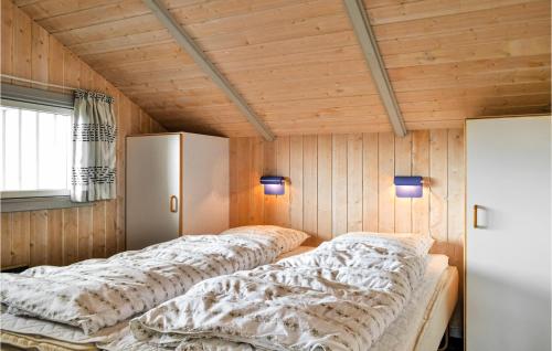 BjerregårdにあるNice Home In Hvide Sande With Wifiのベッド2台 木製の壁の部屋