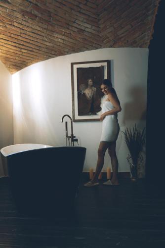 a woman standing in a bathroom next to a bath tub at Dwór Prezydencki Boutique Hotel & SPA in Tarnów