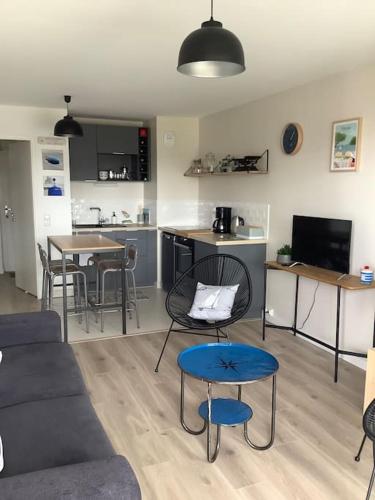 un salon avec un canapé et une table dans l'établissement Carnac grand appartement cosy 2 personnes, à Carnac