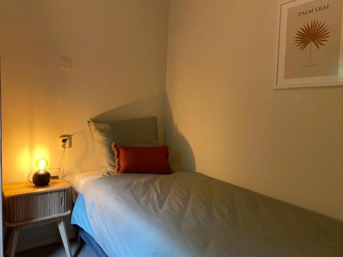 a small bedroom with a bed and a night stand at Chalet de Vinck in Diever in Diever