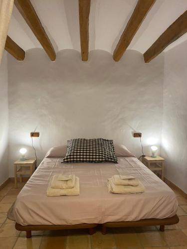 1 dormitorio con 1 cama con 2 toallas en Masia Ca la Jepa, en Juncosa